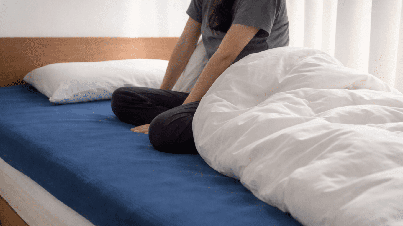 朝スッキリ起きられず布団の上で座り込む人のイメージ｜睡眠姿勢チェックリストと危険サイン（だるさ・頭痛・肩こり）を確認する記事のアイキャッチ
